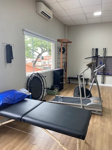 Sala de treino funcional com esteira, mini trampolim e espaldar